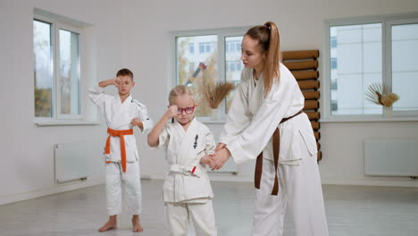 little girl in white kimono in martial arts class