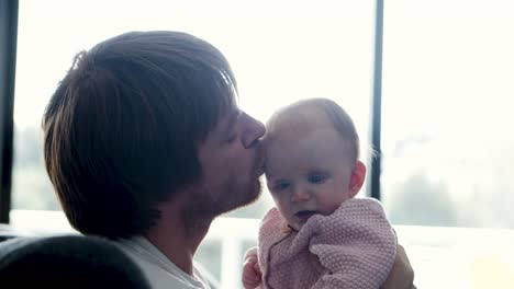 happy dad holding and kissing sweet baby daughter