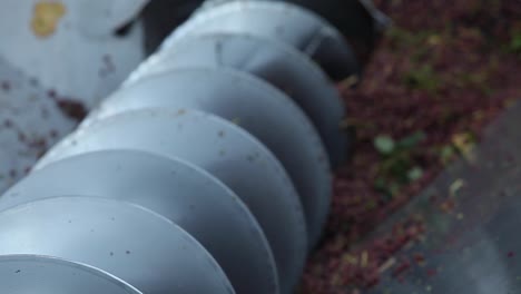 Close-up-of-a-spinning-auger-processing-red-wine-grapes-during-harvest-season-1