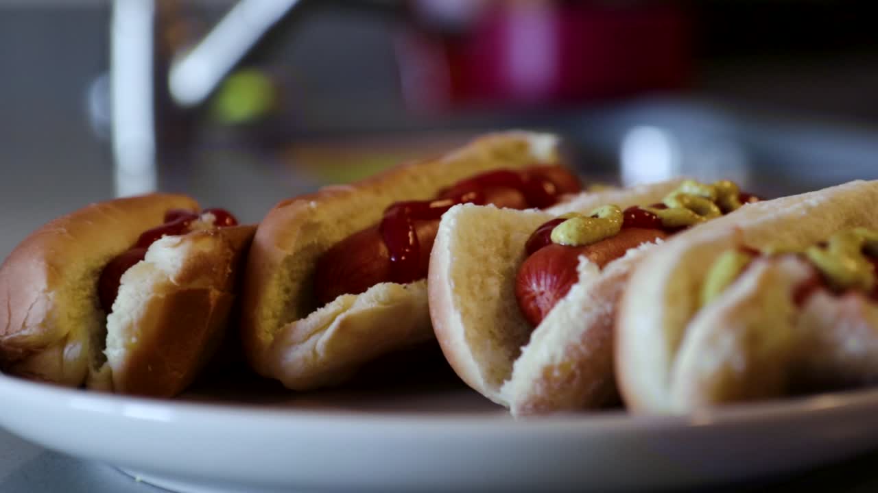 Close up rotating shot of a plate of hotdogs with ketchup and mustard