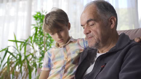 abuelo y nieto leyendo un libro.