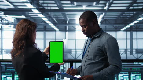 workers using mockup device in server room, checking infrastructure reliability