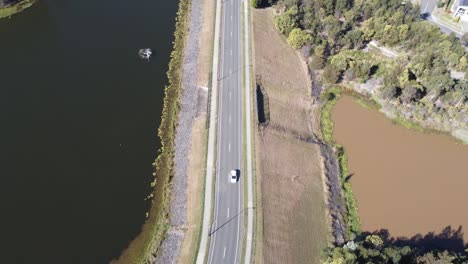 Vista-Aérea-De-Una-Carretera-En-Un-Aliviadero-Cerca-De-Un-Lago-En-Australia