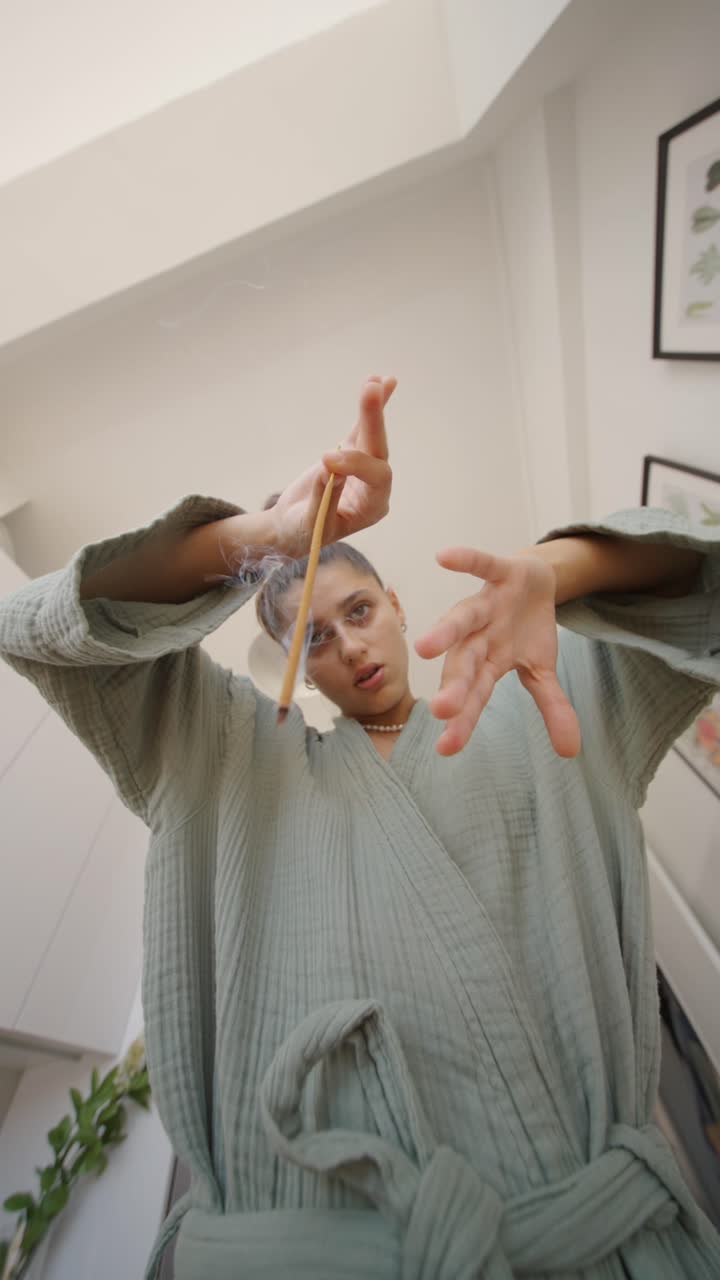 Woman in robe holding incense