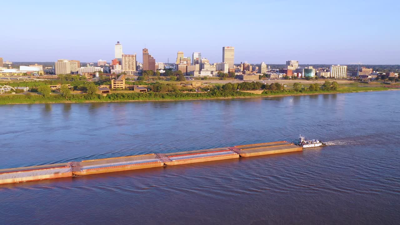 Good aerial over a barge on the Mississippi River with downtown business district of Memphis Tennessee in background 2