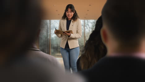 businesswoman or female college teacher giving presentation or lesson in office or classroom 2