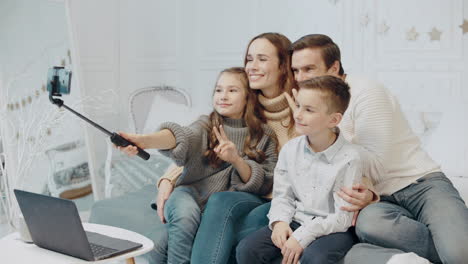 familia alegre posando para una foto móvil en una casa privada.