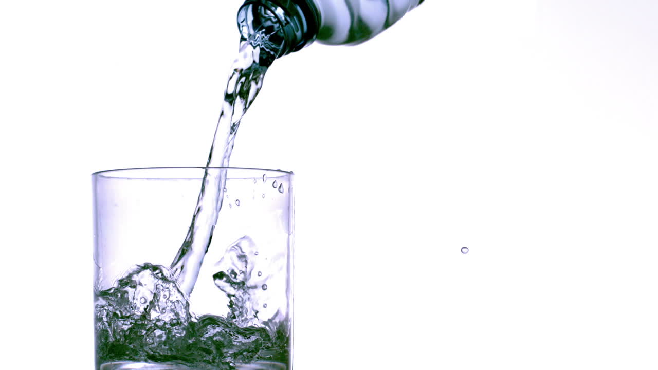 Bottiglia che riempie un bicchiere d'acqua