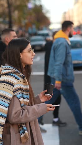 mujer joven con café en el cruce de peatones