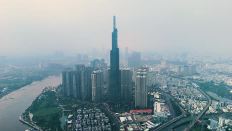 drone shot of landmark 81 supertall skyscraper during the day with pollution in ho chi minh city, vietnam