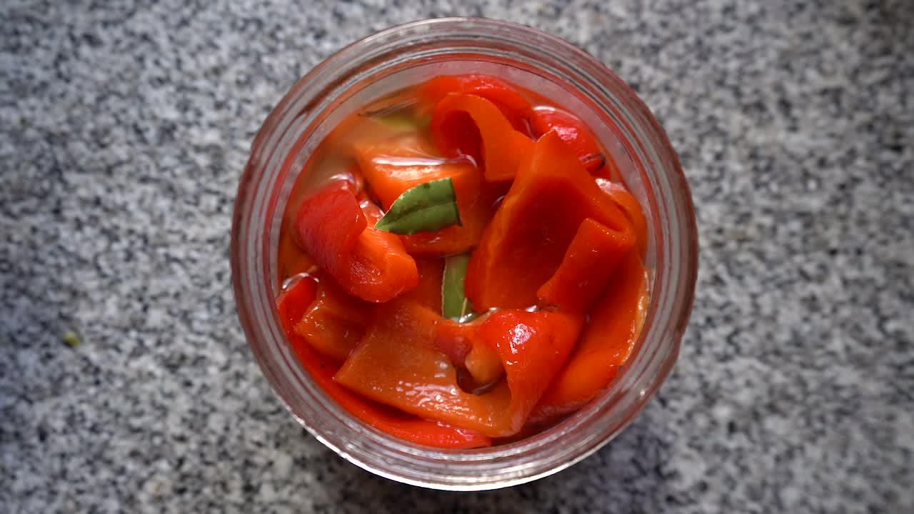 Jar Of Preserved Bell Peppers In Oil. overhead, zoom-out