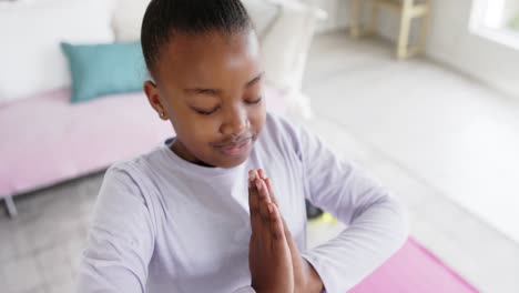 Fröhliches,-Unverändertes-Afroamerikanisches-Mädchen,-Das-Im-Wohnzimmer-Yoga-Macht-Und-Meditiert,-In-Zeitlupe