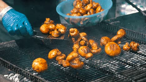 the cook prepares mushrooms on the grill. barbecue party