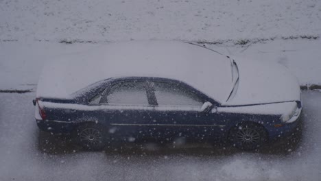 coche aparcado cubierto de nieve durante la tormenta de nieve en riga, letonia