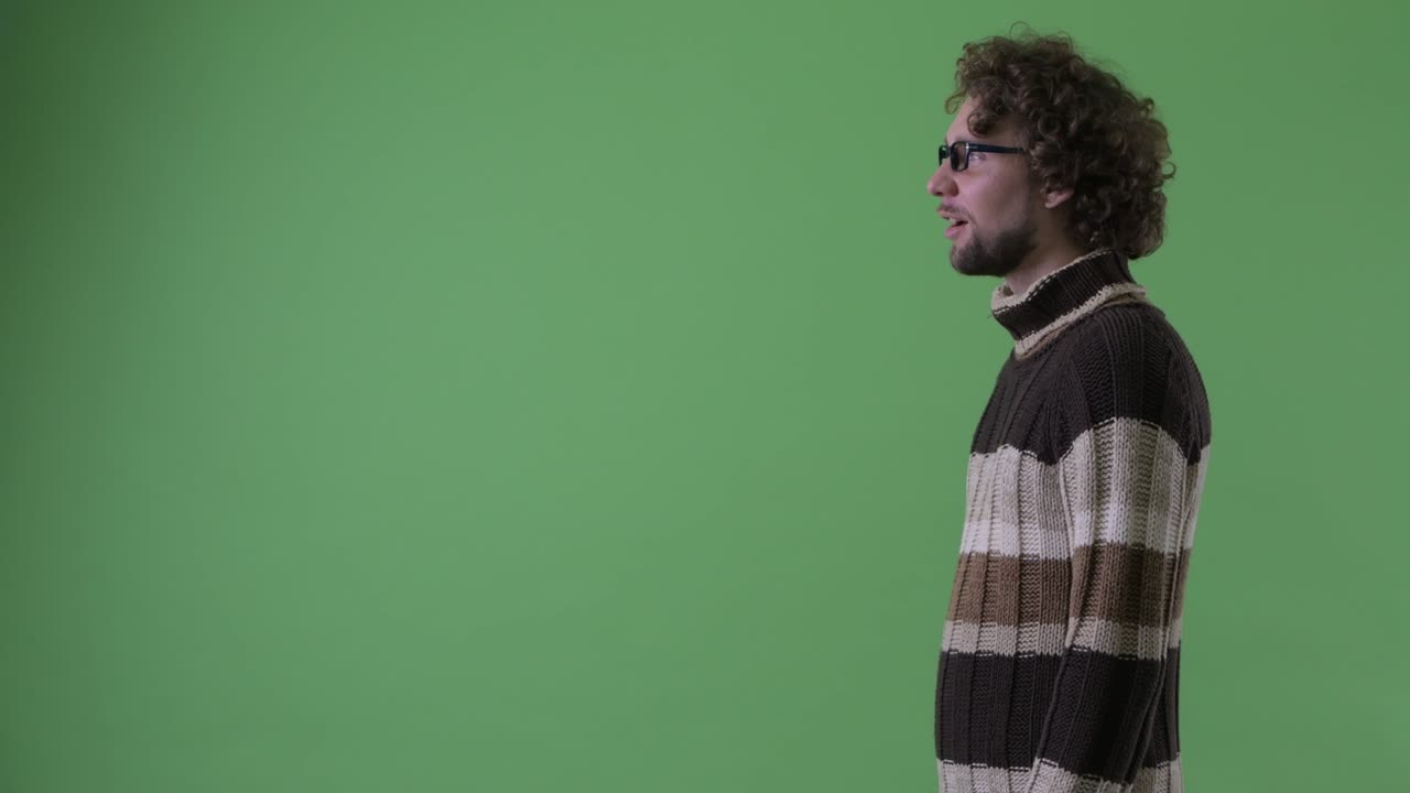 un joven guapo con barba y cabello rizado.