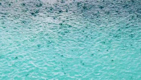 Rain-drops-falling-on-the-water-surface-of-a-swimming-pool