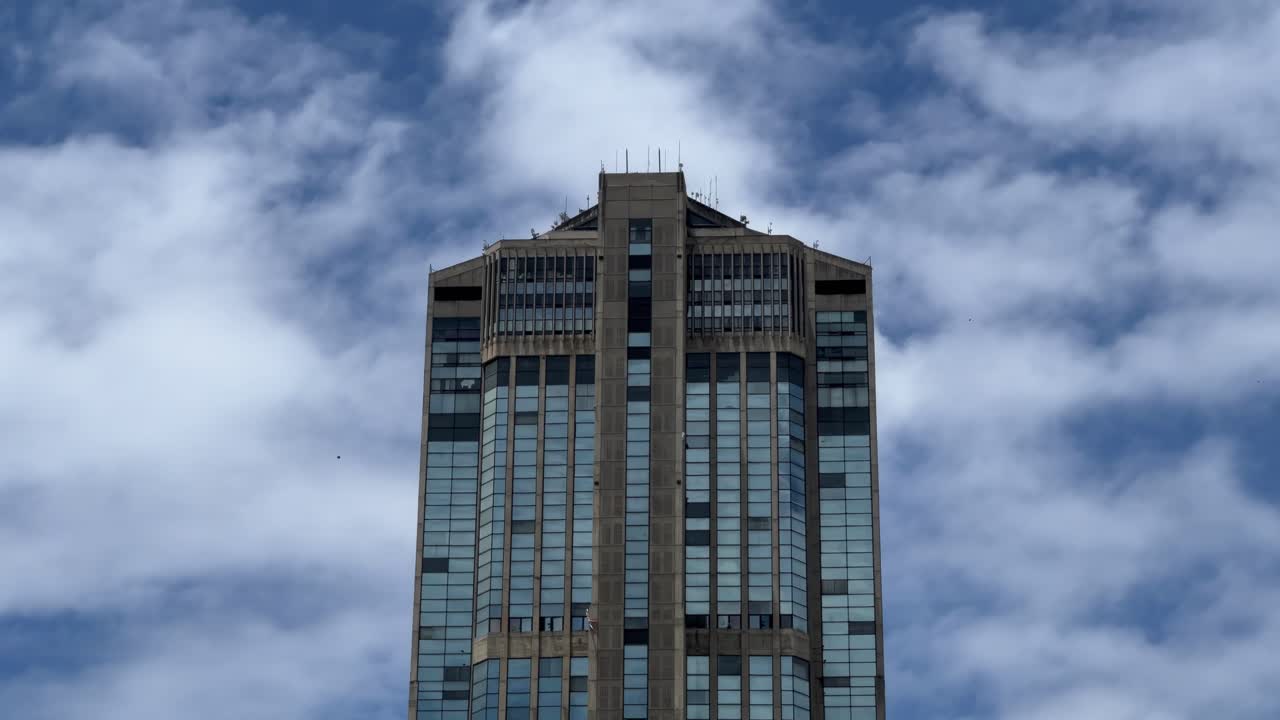 Low angle shot of the top of one of the towers in Parque Central in Caracas, Venezuela with a blue sky with several clouds.