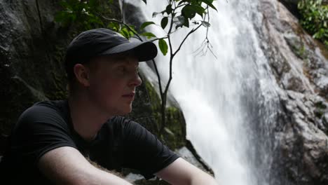 Joven-Caucásico-Descansa-Además-De-Una-Cascada-En-Su-Caminata-Por-La-Selva-Tropical-En-Ihla-Grande-Brasil