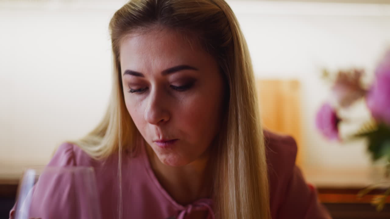 Elegant woman eats salad and drinks collectible wine