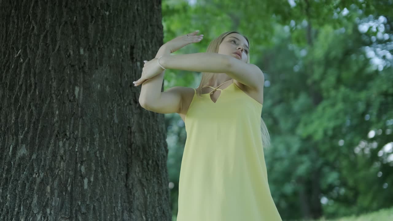 여름 공원에서 나무 에서 춤을 추는 노란색 드레스를 입은 여자
