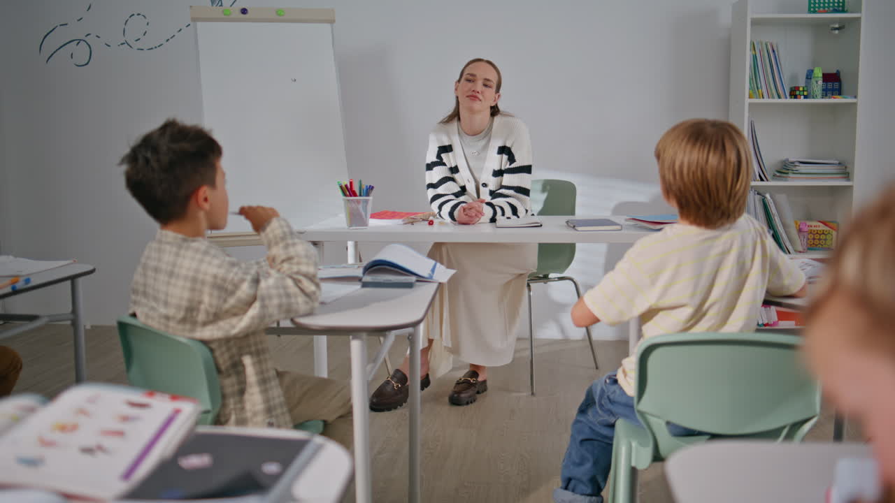 Little schoolchildren doing test listening teacher at school class back view