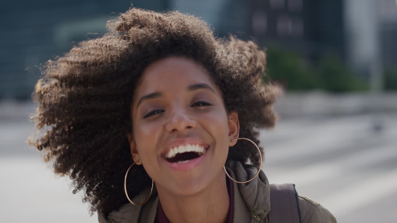 ritratto bella giovane donna afroamericana che ride godendo di uno stile di vita urbano di successo indipendente studentessa nera alla moda afro acconciatura faccia toccante