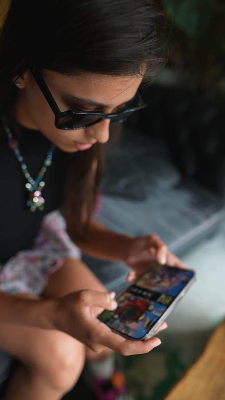 una mujer joven jugando a un juego en su teléfono en un café.