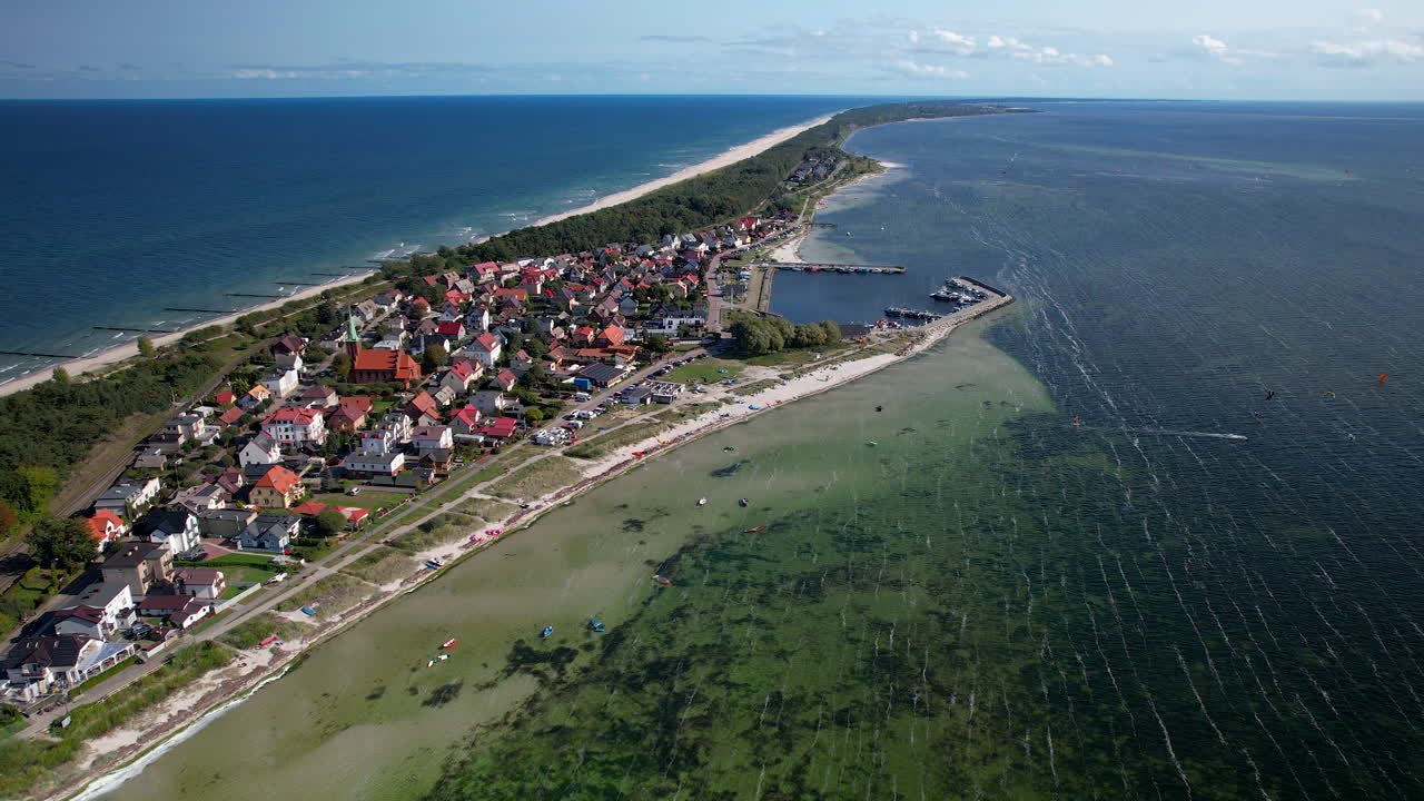 폴란드의 발트해의 산호초와 모래 해변과 함께 젤 섬의 쿠즈니카 마을을 보여주는 항공 후방 촬영