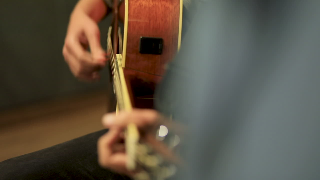Close-up of a man playing the guitar in the studio