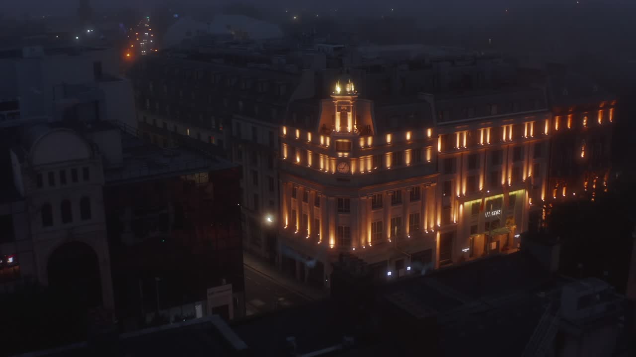 럭셔리 호텔의 조명 된 역사적인 건물의 영상을 끌어내십시오. 탑과 시계가있는 모이. 아일랜드 더블린의 밤에 안개가 있습니다.