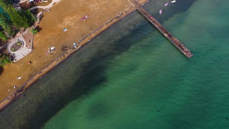 Aerial-view-tilting-away-from-a-a-beach-on-the-coast-of-Lake-Tahoe,-in-sunny-USA