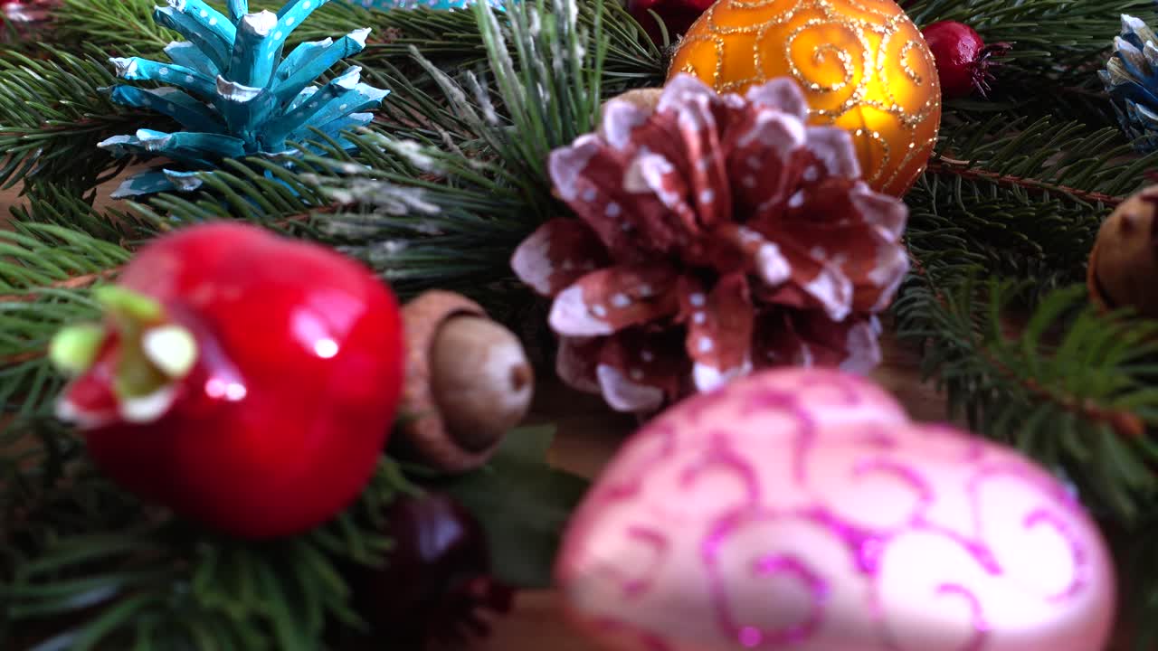 Enfeites de Natal coloridos e pinhas em ramos de árvores perenes