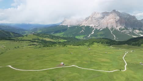 aerial tilt down view of the lush green meadows of pralongia in the italian dolomites