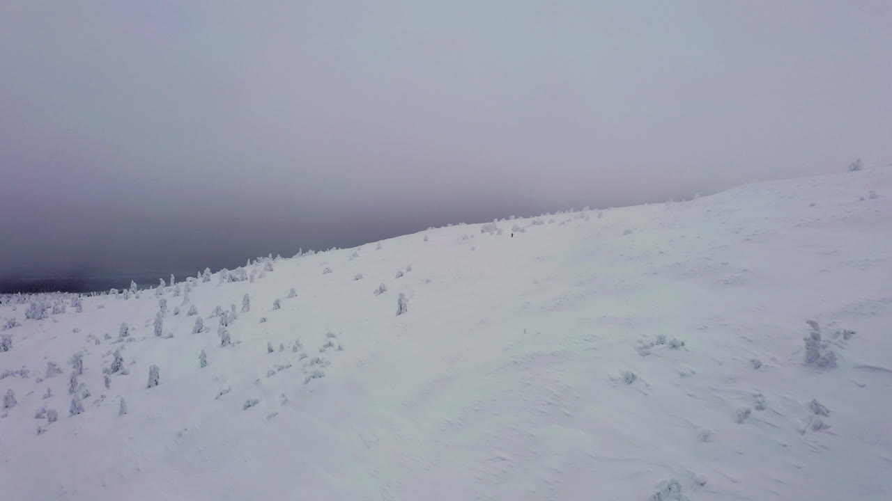 Aerial view over the snowy tunturi mountain, gloomy winter day, in Lapland