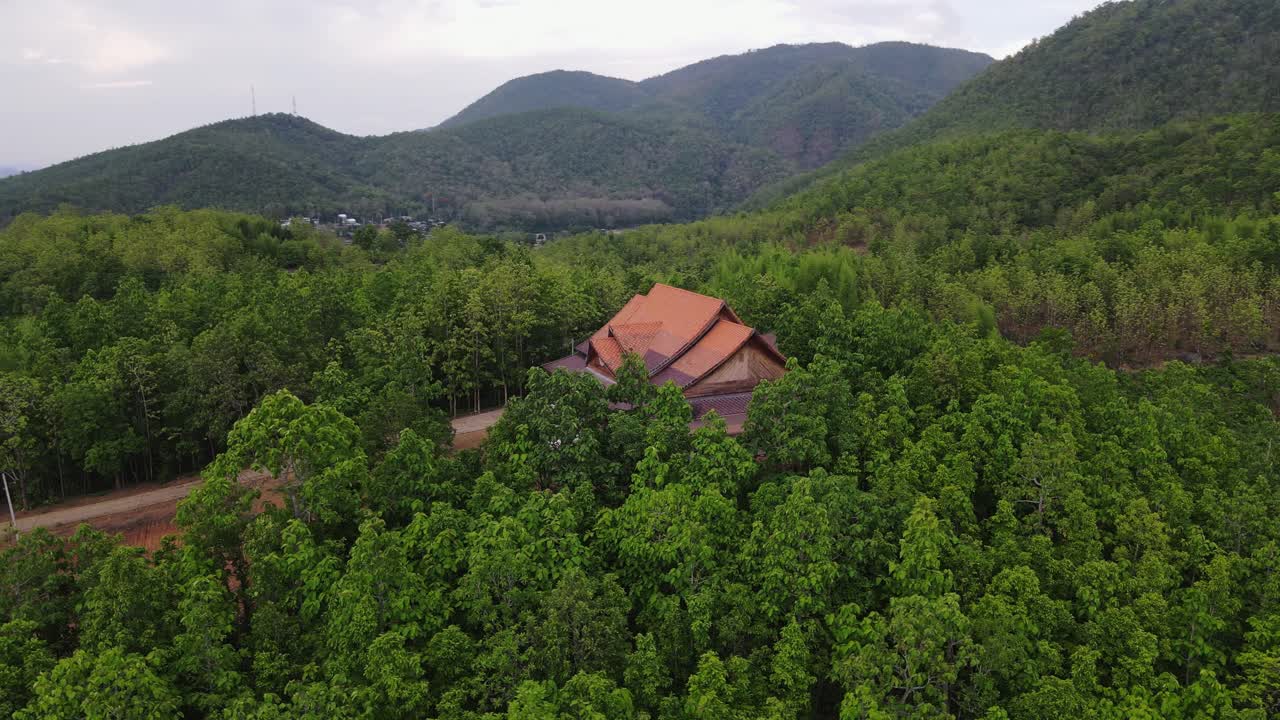toma aérea de una casa sola situada entre el denso bosque en ban mae saring, chiang mai, tailandia