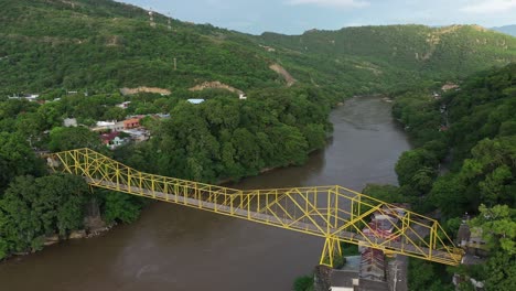 vista aérea de drones, puente amarillo sobre el fangoso río magdalena en el verde paisaje de las tierras altas colombianas cerca de la ciudad de honda, región del tolima, tiro revelador