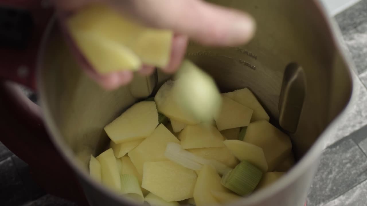 Hand putting ingredients into a soup maker close up shot