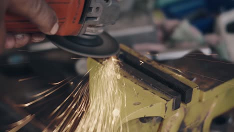 trabajador que utiliza una herramienta de rueda eléctrica para moler y cortar la estructura de acero