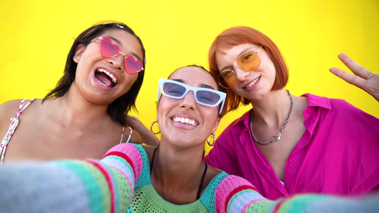 Three Young Women Taking a Selfie Against a Yellow Wall