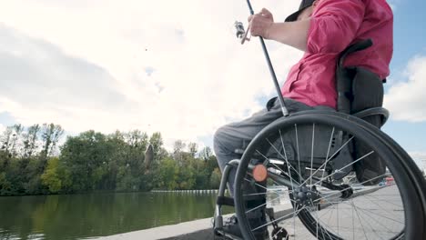 person with a physical disability who uses wheelchair fishing from fishing pier