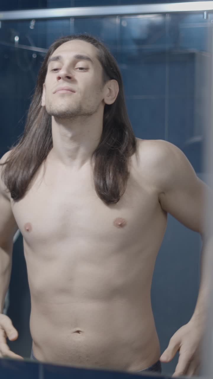 Man Examining His Body in a Bathroom Mirror, Showing Self-Consciousness
