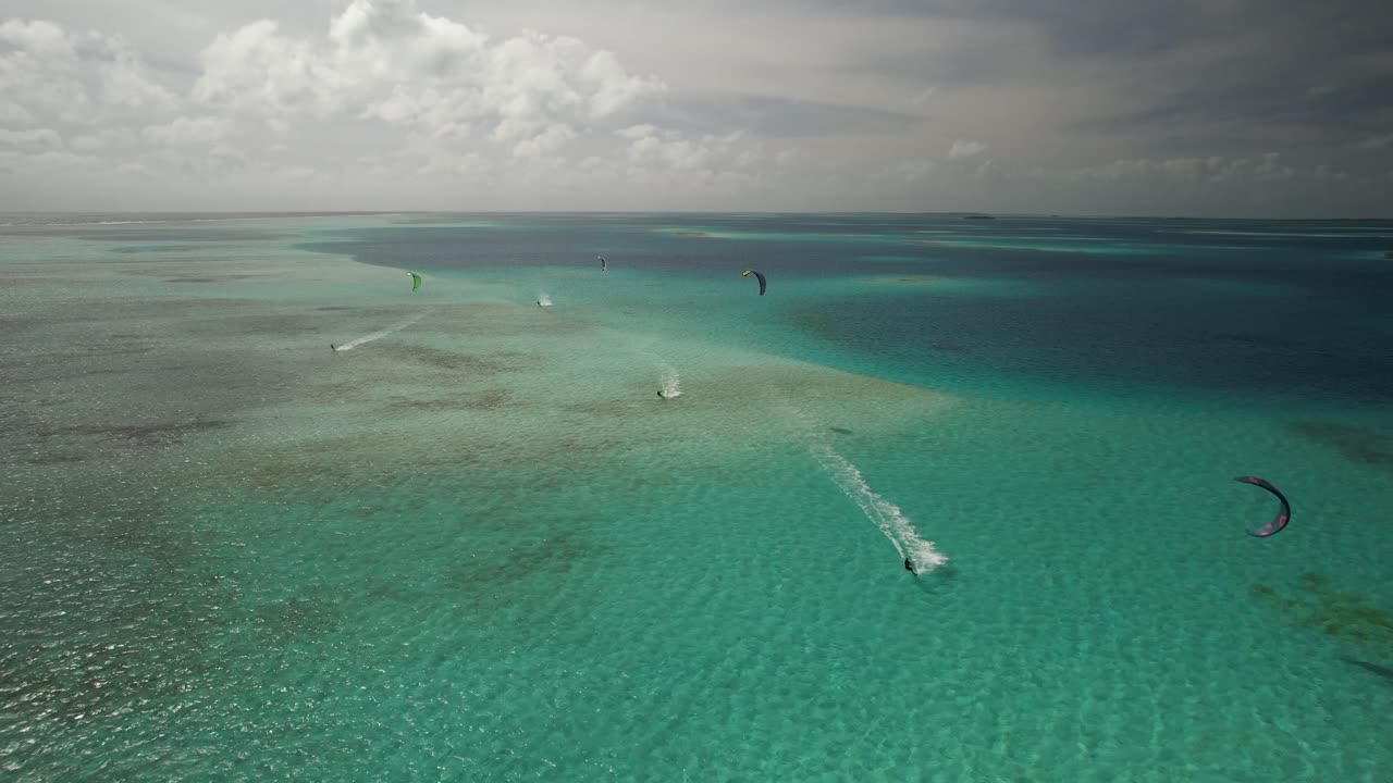 푸른 물 위를 날아다니는 카이트 서퍼, 넓은 바다 전망, 조용한 분위기, 공중 전망