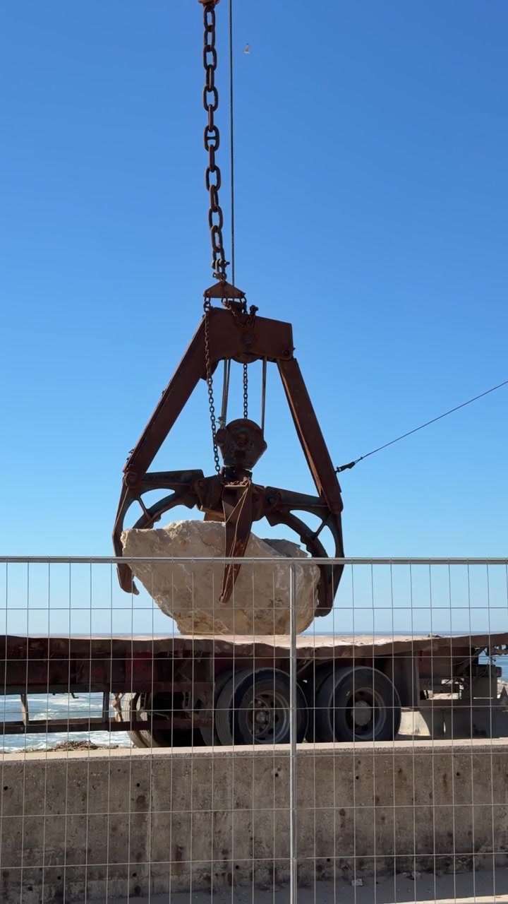 Punto di Vista di una Gru che Estrae una Roccia Pesante dal Camion a Furadouro, Portogallo. Concetto di Protezione Costiera