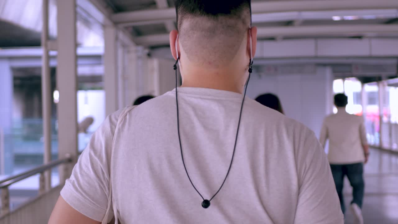 방콕 시내에서 스카이워크를 걷는 동안 아시아 남자의 등에 pov