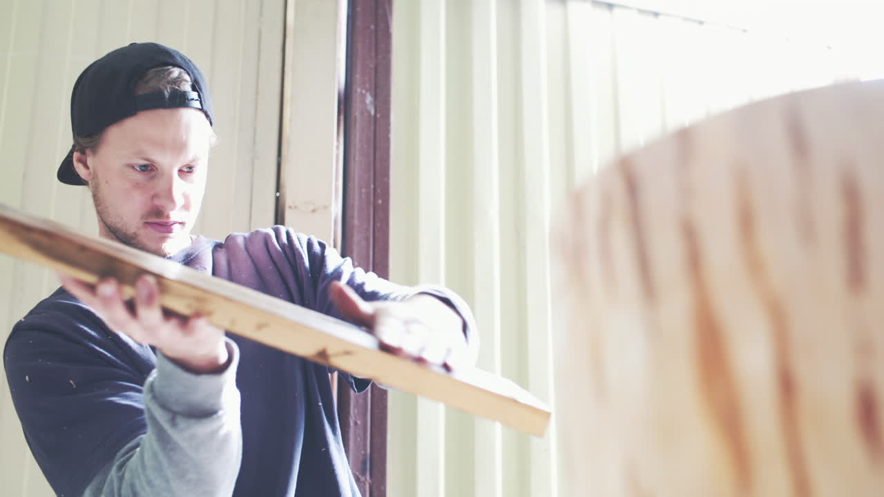Artigiano che ispeziona e modella un pezzo di legno in officina