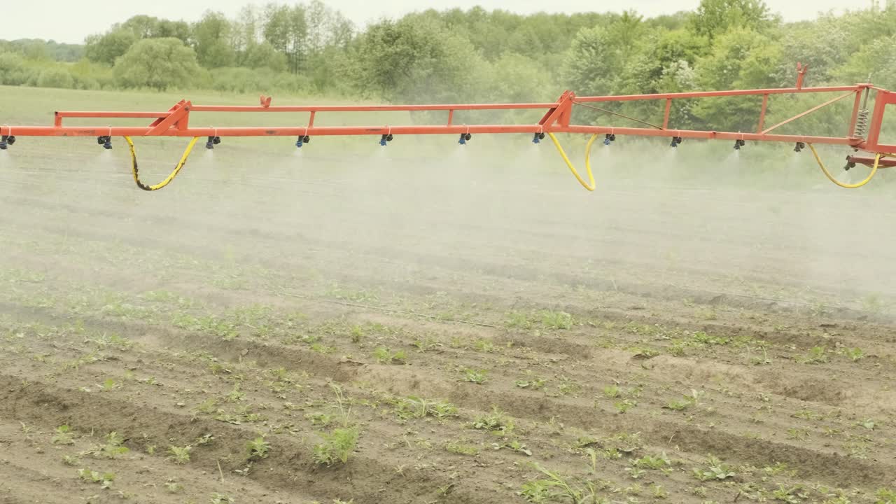 Agricultural tractor is fertilizing crop field with fertilizer nutrients