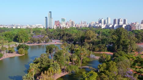 vista aérea estableciendo el lago de la rosaleda de palermo con los edificios residenciales de buenos aires en el fondo, argentina