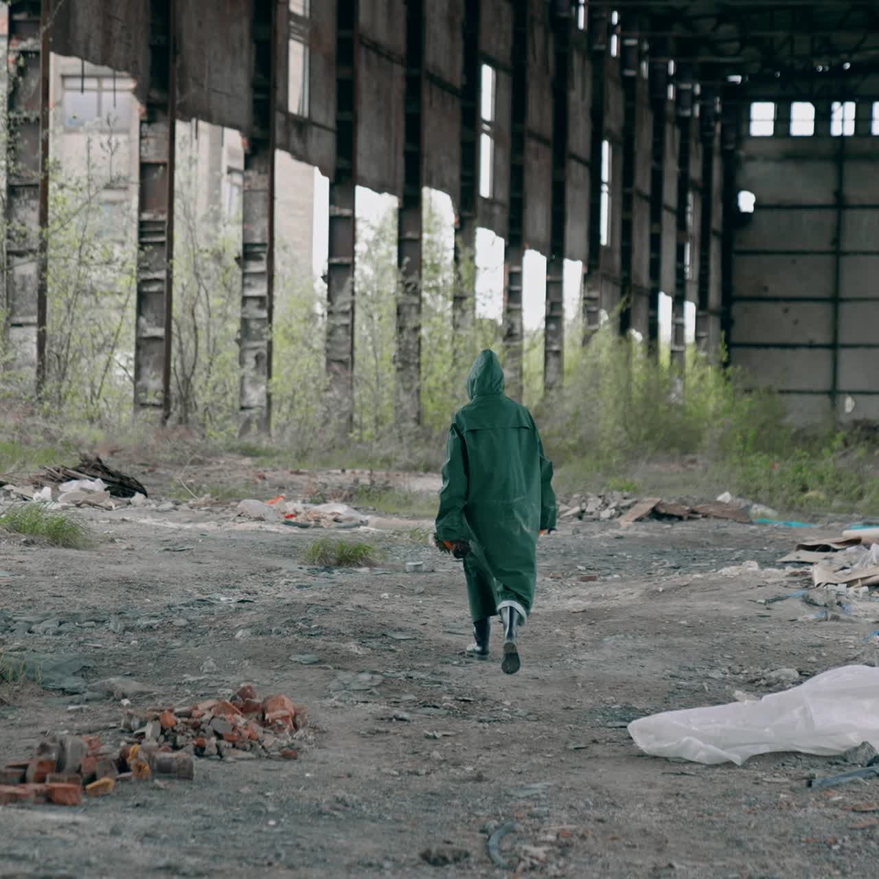 Radioactive zone. Human in safety uniform and gas mask in abandoned building with ruined walls and roof. Chemical attack. Air pollution