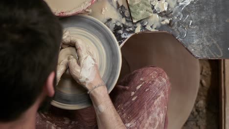 the potter makes a jug of clay. ceramist. a man makes a vase on a potter's wheel