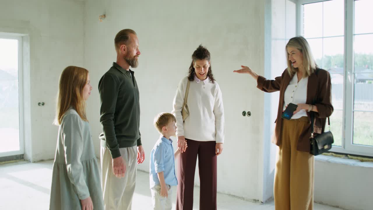 Familie ser på en ny bolig under opførelse